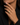 A close-up of a person's hand wearing a gold signet ring with a clear cushion-cut gemstone, styled with a black blazer.