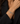 A close-up of a person wearing a silver chain-link toggle bracelet on their wrist, dressed in a black blazer.