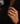 A close-up of a person's hand wearing a silver-toned emerald-cut diamond ring, set against a dark black blazer.