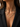 A close-up of a model wearing a delicate gold butterfly necklace with small clear stones, styled with a black blazer.