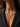 A close-up of a model wearing a gold butterfly necklace with small clear stones, styled with a black blazer.