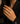 A close-up of a model's hand wearing a gold ring with a textured, diamond-like patterned face, styled with a black blazer. A decorative 'D' monogram watermark is visible in the bottom-left corner.