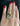 A close-up of a hand with red nail polish wearing a two-tone ring with one gold band and one silver pavé band, set against a dark background.